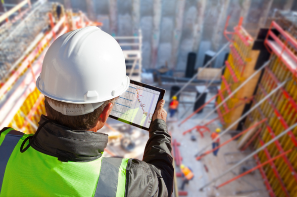 Surveyor wearing protective gear at a building site
