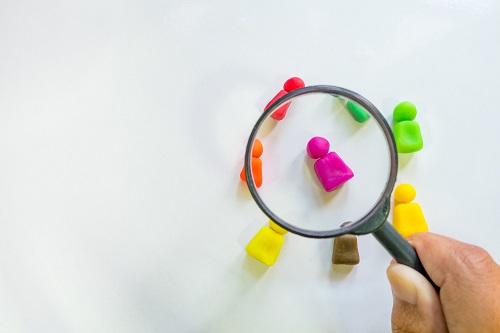 A magnifying glass over icons of people